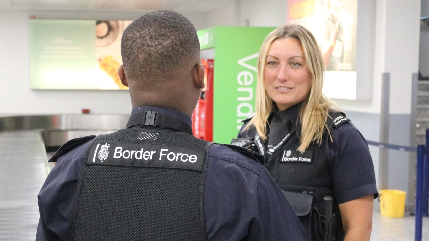 A female Border Force employee speaks with her male colleague